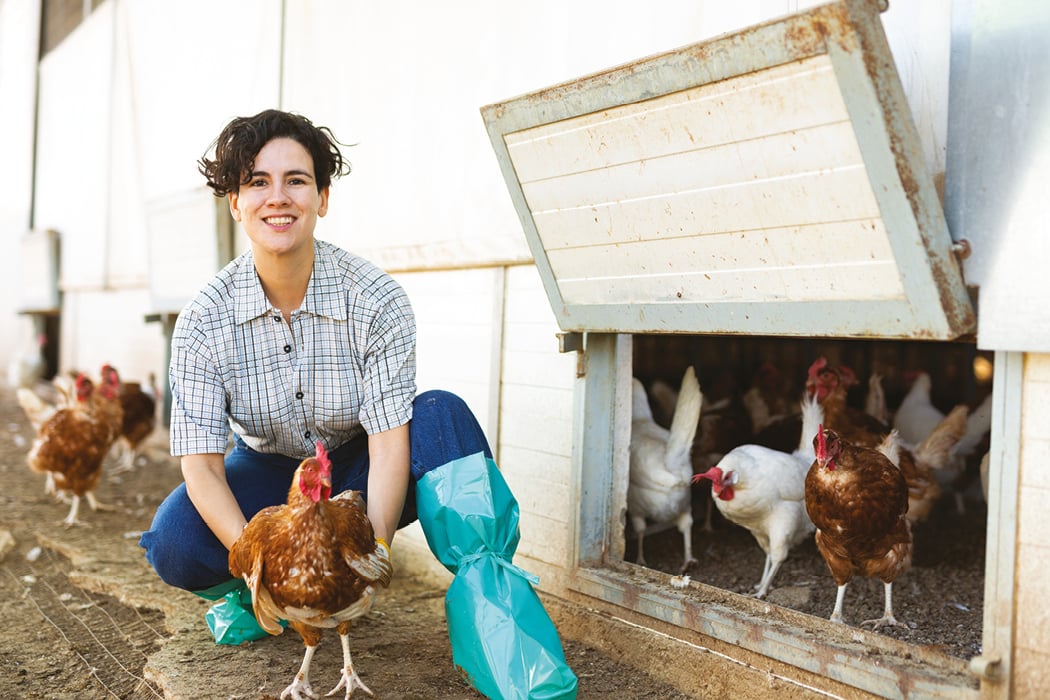 Contadina che tiene una gallina ovaiola